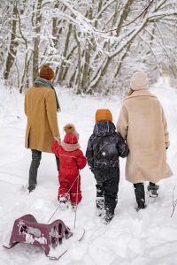 Family playing in snow in January, Financial Wellness Month