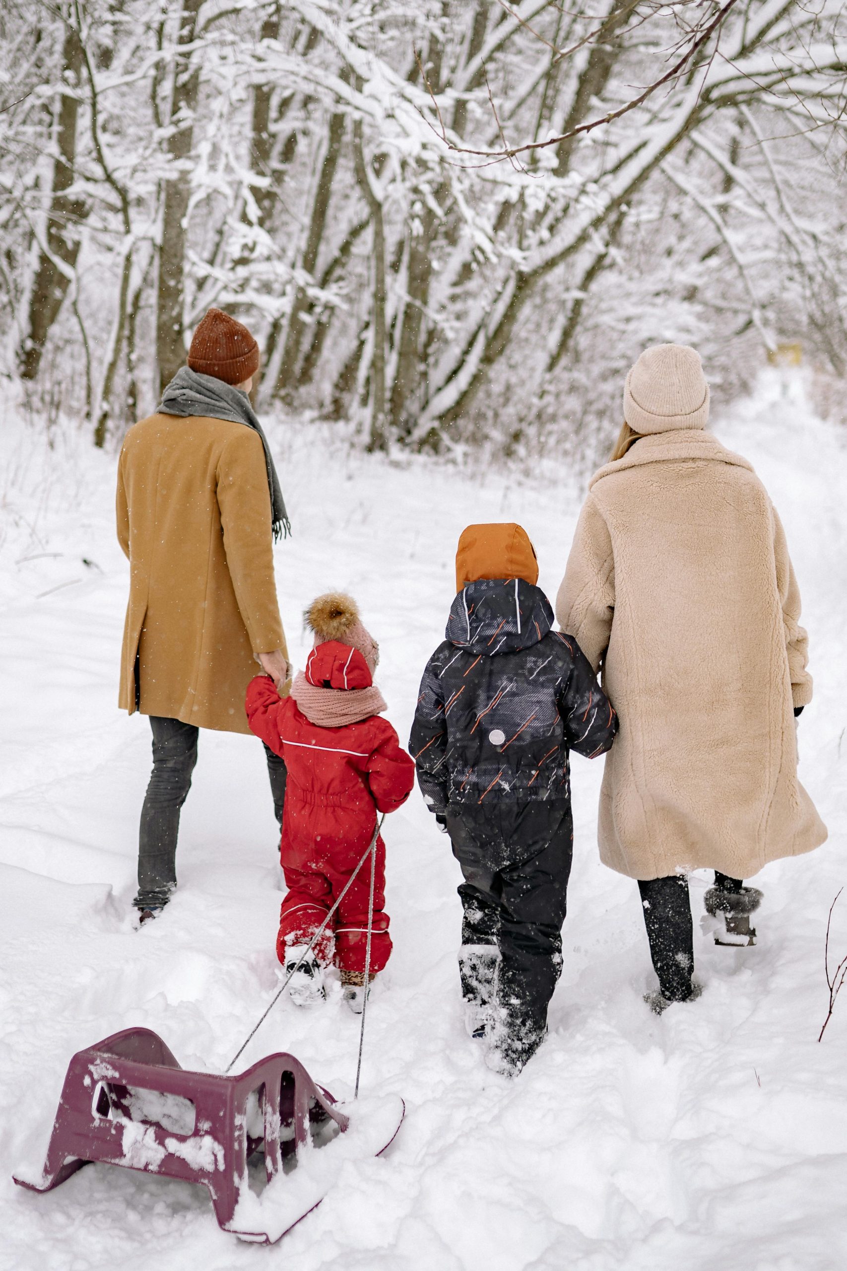 Family playing in snow in January, Financial Wellness Month