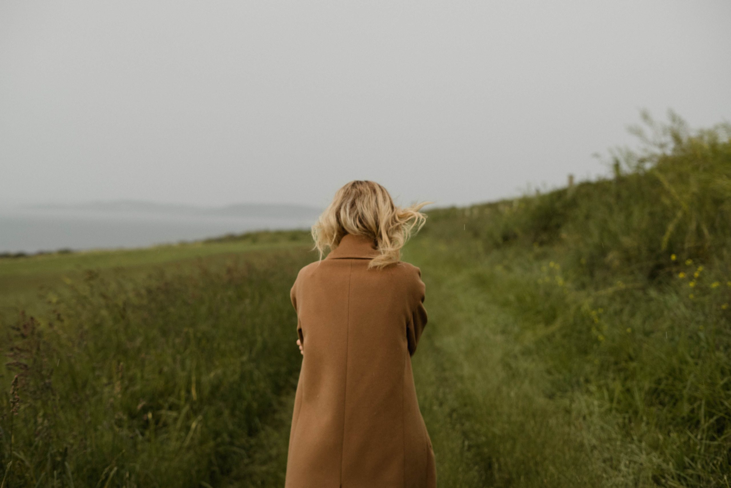 Person walking along a quiet nature path, symbolizing a new direction and independence.